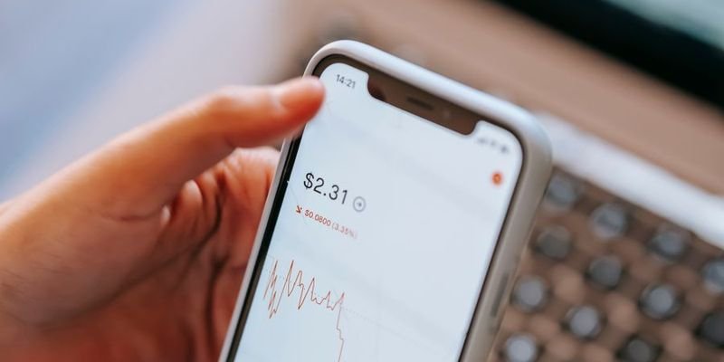 Person checking an investment chart on a smartphone, representing demat conversion